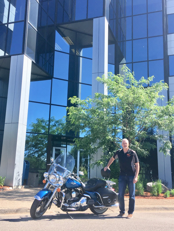 Attorney David M. Bialke in a leather motorcycle jacket, pictured with his Harley Davidson motorcycle.